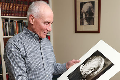 Donor looking at photo of Albert Einstein. Links to Tangible personal property. 